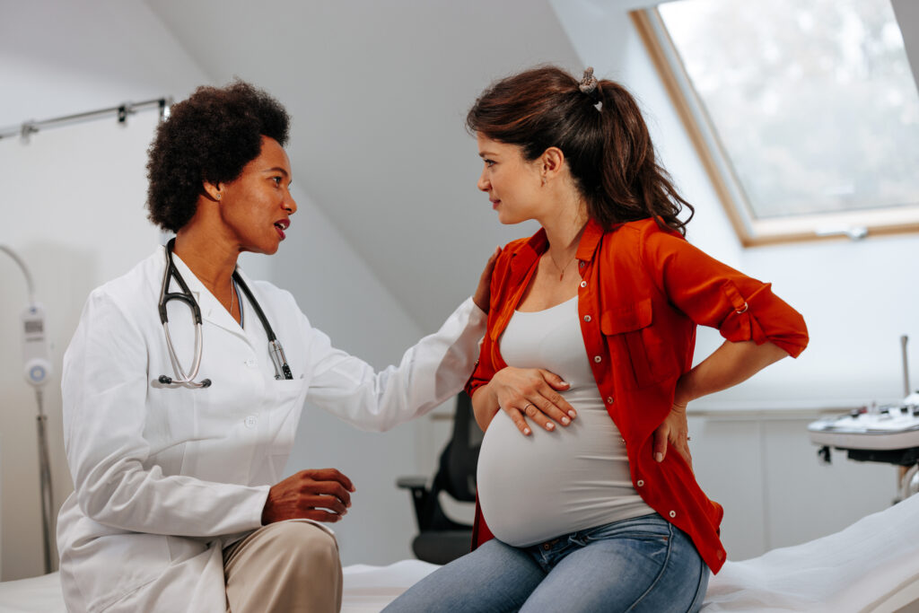 A mid adult female doctor is in the office with a pregnant woman giving her advice about pregnancy.